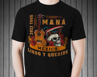 Könnte beinhalten: Schwarzes T-Shirt mit einem grafischen Design mit einer Gitarre, einem Schädel und Rosen. Der Text "2023 TOUR MANÁ MÉXICO LINDO Y QUERIDO" ist auf dem Shirt aufgedruckt.