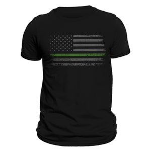 May include: Black t-shirt with a distressed American flag design featuring a thin green line across the middle.