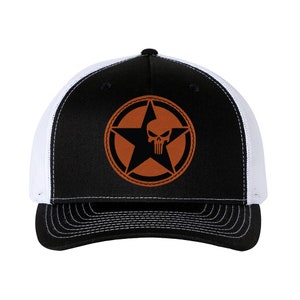 Peut inclure: Casquette de camionneur noire et blanche avec un design d'étoile et de crâne brun. L'étoile a un contour blanc et le crâne est noir.