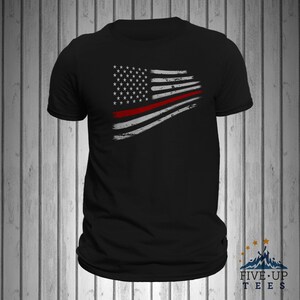 May include: Black t-shirt with a distressed American flag design featuring a red stripe across the middle.