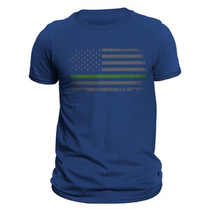 May include: A royal blue t-shirt with a distressed American flag design. The flag has a green stripe across the middle.