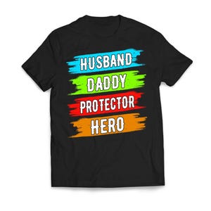 May include: Black t-shirt with colorful brushstrokes and the text "Husband Daddy Protector Hero" in white.