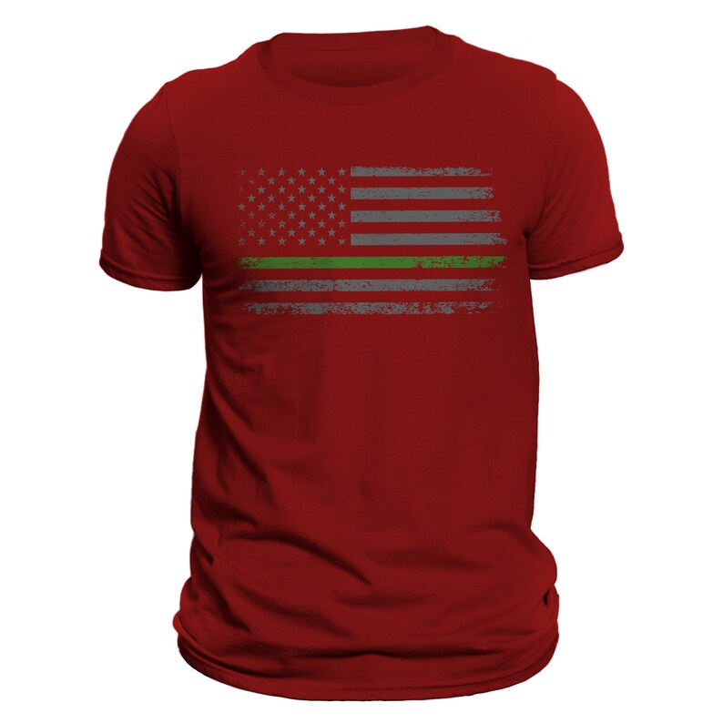 May include: Red t-shirt with a distressed American flag design featuring a thin green line across the middle.