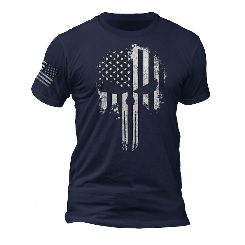 May include: A navy blue t-shirt with a white distressed American flag skull graphic.