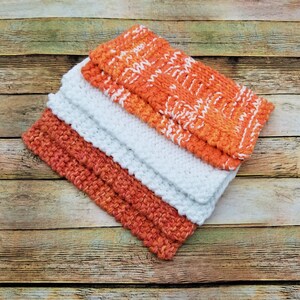 Samples of Spainhour Thanksgiving dishcloth knitting pattern knit with orange, white and variegated yarn