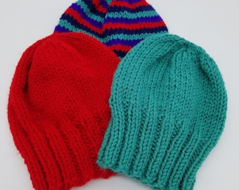 May include: Three knitted hats in different colors and patterns. One hat is red, one is teal, and one is striped with blue, purple, and red.