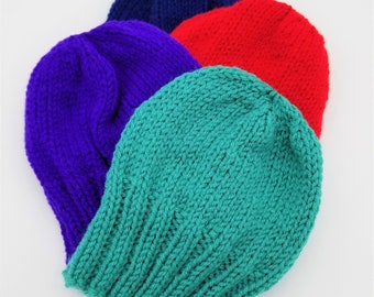May include: Four knitted hats in different colors: teal, purple, red, and navy blue. The hats are stacked on top of each other.