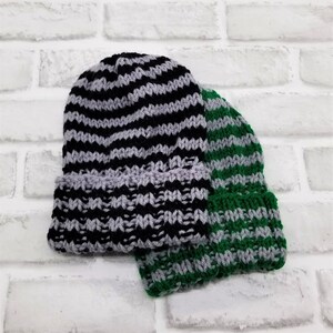 May include: Two striped knit hats, one black and grey, the other green and grey.
