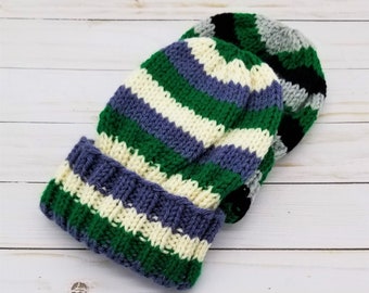 May include: Two knitted hats, one with green, white, and purple stripes and the other with black, gray, and white stripes.