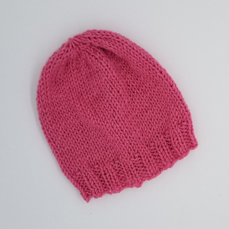 May include: A pink knitted beanie hat.