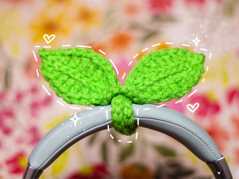 May include: Green crocheted leaf-shaped headphone covers. The covers are attached to the headband of a pair of gray headphones.