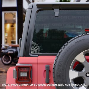 May include: A white spider web decal applied to the rear side window of a red vehicle. The decal features a corner-aligned web pattern. The text "NOTE: PHOTOSHOPPED TO SHOW DESIGN, SIZE NOT ACCURATE" is printed in white at the bottom of the image.