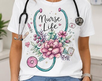 May include: A white short-sleeved t-shirt featuring a graphic print of a teal stethoscope shaped like a heart, filled with pink and purple flowers. The text Nurse Life is printed in black script. Additional icons include a syringe, bandage, and clipboard.