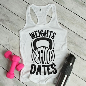 May include: White tank top with black text that reads "Weights Before Dates" with a black kettlebell graphic around the word "Before".