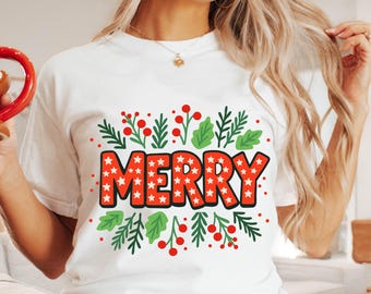 Könnte beinhalten: Weißes T-Shirt mit dem Wort "MERRY" in einem festlichen Design. Das Wort ist rot mit weißen Sternen, umrahmt von grünen Blättern und roten Beeren. Ein fröhliches Design für die Weihnachtszeit.