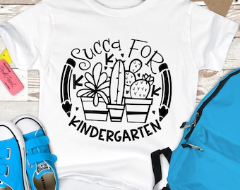 Könnte beinhalten: Weißes T-Shirt mit einem schwarz-weißen Grafikdesign eines Kreises mit dem Text "Succ For K Kindergarten" und drei Topfkakteen.
