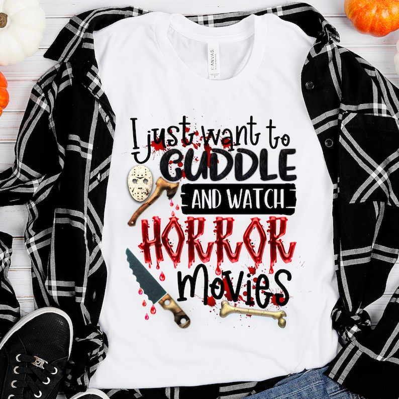 K&ouml;nnte beinhalten: Wei&szlig;es T-Shirt mit rotem, blutigem Text, der "Ich m&ouml;chte mich nur kuscheln und Horrorfilme schauen" sagt. Der Text ist von einem blutigen Messer, einem Knochen und einer Hockeymaske umgeben.