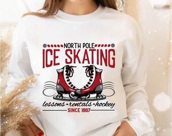 May include: White sweatshirt with red text that reads "North Pole Ice Skating" with a graphic of two red ice skates. The text below the graphic reads "lessons rentals hockey since 1867".