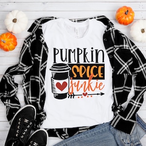 May include: White t-shirt with the text "Pumpkin Spice Junkie" in black and orange lettering. A black and white illustration of a coffee cup with a red heart is next to the text.