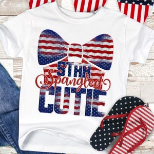 May include: White t-shirt with a red, white, and blue bow tie design. The text "Star Spangled Cutie" is printed on the shirt in a red, white, and blue font.