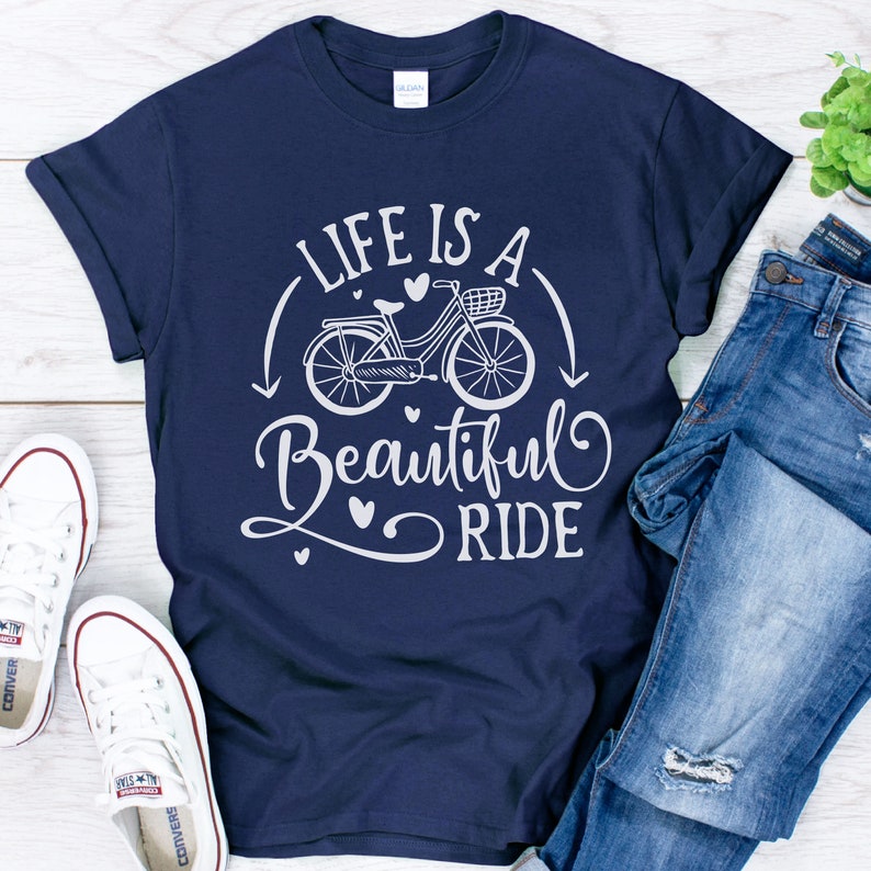 May include: A navy blue t-shirt with a white graphic design of a bicycle with the text "Life is a Beautiful Ride".