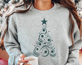 Könnte beinhalten: Hellgraues Sweatshirt mit einem dunkelgrünen Weihnachtsbaum-Design. Der Baum besteht aus wirbelnden Linien, Kreisen und einem Stern an der Spitze. Das Sweatshirt hat einen Rundhalsausschnitt.