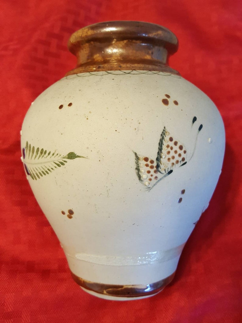 It/'s very unique and pretty. It has butterflies and flowers Hand painted ceramic vase from Mexico leaves