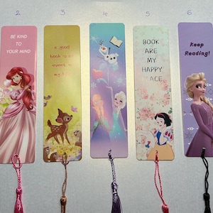 Peut inclure: Ensemble de sept marque-pages colorés avec des personnages Disney et des citations inspirantes. Les motifs incluent Ariel, Elsa, Blanche-Neige et Bambi. Chaque marque-page est orné d'un pompon.
