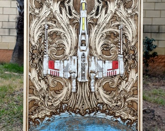 May include: A wooden plaque with a detailed carving of a starfighter spaceship surrounded by ornate floral designs. The spaceship is white with red and yellow accents. The background is a dark brown wood.