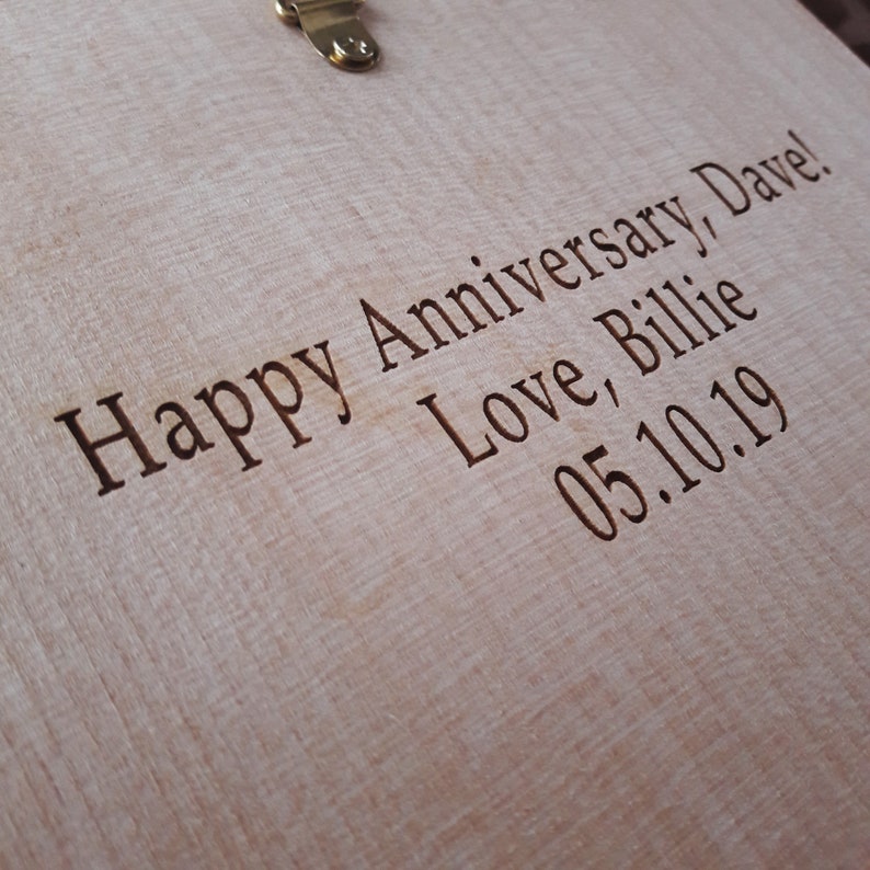 May include: A close-up of a wooden surface with the text "Happy Anniversary, Dave! Love, Billie 05.10.19" engraved on it.