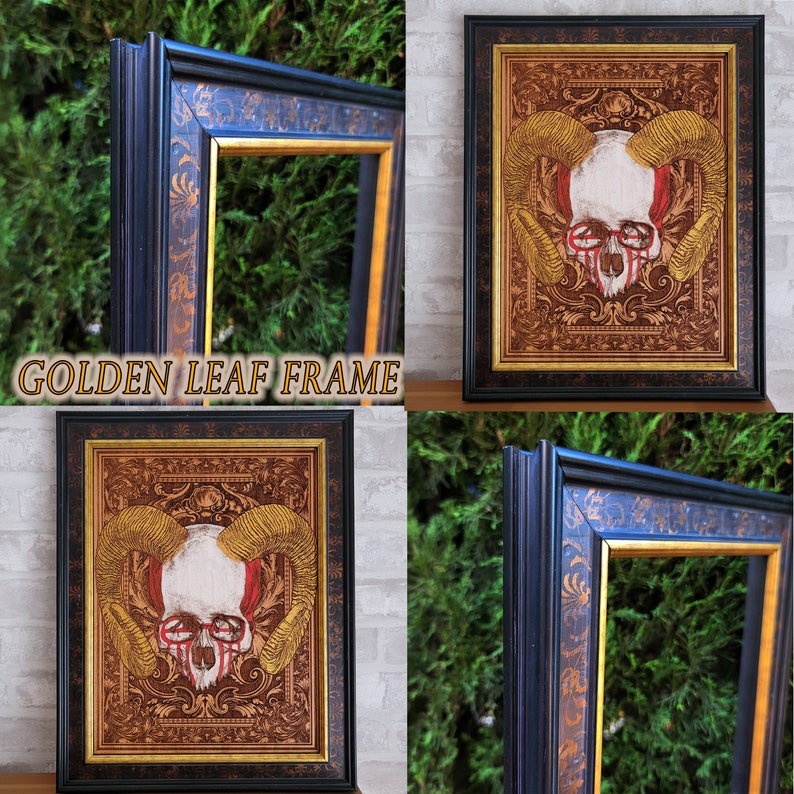 May include: A black frame with gold leaf detailing surrounds a print of a skull with horns. The skull is white with red accents and is set against a brown background with gold leaf details. The frame is labeled "GOLDEN LEAF FRAME".