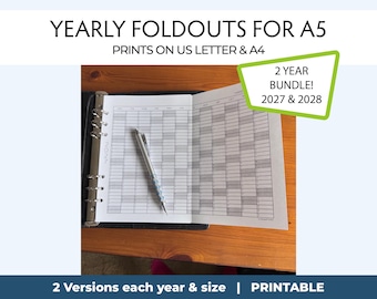May include: A yearly foldout planner insert for A5 binders, compatible with US Letter and A4 paper. The white paper features a grid layout for 2027 and 2028. A silver mechanical pencil rests on the open pages. Text includes 2 YEAR BUNDLE! 2027 & 2028.