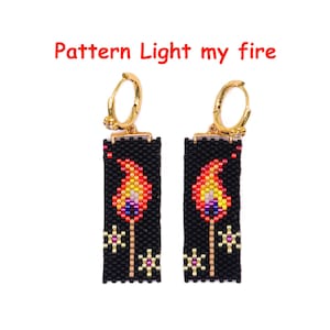 May include: A pair of beaded earrings with a black background and a flame design. The flames are in shades of red, orange, yellow, and purple. The earrings have gold-colored hoops and the text "Pattern Light my fire" is above the earrings.