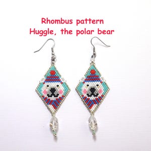 Könnte beinhalten: Paar rautenförmige Ohrringe mit einem Eisbären-Design. Die Ohrringe sind aus kleinen, farbigen Perlen in Blau-, Rot-, Weiß- und Schwarztönen gefertigt. Der Text "Rhombus pattern Huggle, the polar bear" steht über den Ohrringen.