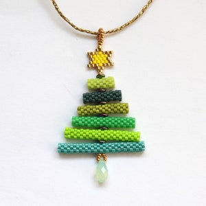May include: A beaded Christmas tree pendant necklace. The tree is made of various shades of green beads, with a yellow star at the top and a pear-shaped green bead at the bottom. The chain is gold-coloured.
