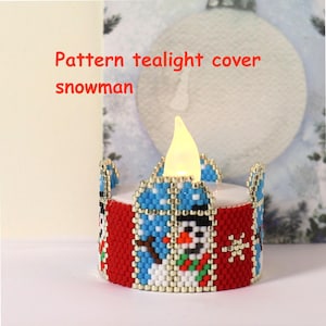Könnte beinhalten: Ein perlenbesetzter Teelichthalter mit Schneemann-Design. Die Abdeckung ist rot mit einem blau-weißen Schneemannmuster und silbernen Akzenten. Der Text "Pattern tealight cover snowman" ist sichtbar.