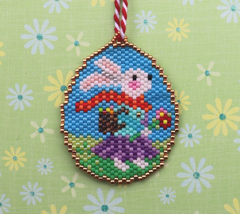 May include: A round, beaded ornament featuring a white bunny holding a basket of colourful eggs. The bunny is wearing a red and orange scarf and is surrounded by green and purple beads.