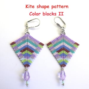 Könnte beinhalten: Ein Paar handgefertigte Ohrringe in Drachenform mit einem farbenfrohen Perlenmuster in Lila, Grün, Blau und Braun. Die Ohrringe haben silberfarbene Klappbügelverschlüsse und eine hängende Lavendelperle. Der Text "Kite shape pattern Color blocks II" ist sichtbar.