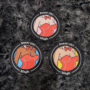 May include: Three round embroidered patches featuring a cartoon image of a woman in a red dress and a bow tie. The text "Bunny Girl" and "Magic" are printed on each patch in a circular pattern.