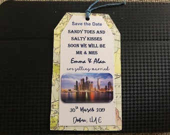 May include: Save the Date card with a cityscape photo and the text "Sandy Toes and Salty Kisses. Soon we will be Mr & Mrs Emma & Alan are getting married. 30th March 2019 Dubai, UAE"