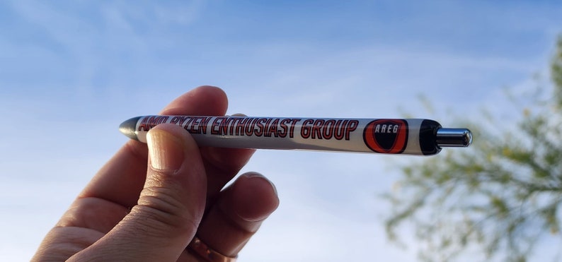 May include: A white pen with a red and black logo that says "Audio System Enthusiast Group" and "AREG".