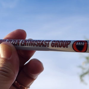 May include: A white pen with a red and black logo that says "Audio System Enthusiast Group" and "AREG".