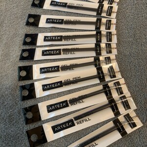 K&ouml;nnte beinhalten: Ein Stapel von zehn schwarzen Gel-Stiftminen, verpackt in durchsichtigen Plastikverpackungen mit dem Markennamen "ARTEZA" und dem Text "GEL PEN REFILL" auf jeder Verpackung. Die Minen sind mit "BLACK INK" und "MEDIUM POINT 0.7" beschriftet.