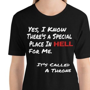 May include: Black t-shirt with white text that reads "YES, I KNOW THERE'S A SPECIAL PLACE IN HELL FOR ME. IT'S CALLED A THRONE". The word "HELL" is in red.