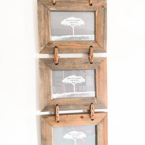 Può includere: Una decorazione da parete verticale composta da tre cornici rettangolari in legno collegate da una spessa corda di juta. Ogni cornice presenta un inserto grigio con un grafico di un albero bianco e il testo "Made from sustainably sourced wood 6x4".