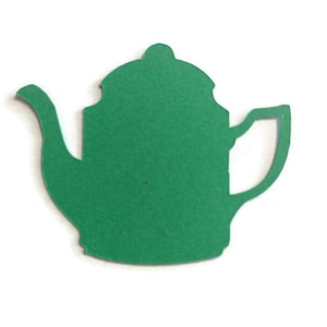 May include: A green paper teapot cutout. This is a craft supply for scrapbooking, card making, or other paper crafts.