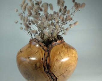 Handmade apricot wood vase with natural edge for dried flowers.