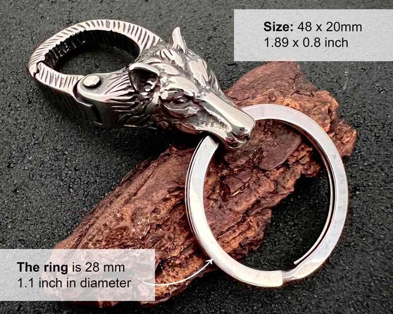 May include: A silver-colored keychain featuring a wolf head design. The keychain includes a large ring and a clasp. The wolf head is intricately detailed. The keychain measures 1.89 x 0.8 inches (48 x 20mm), with a ring diameter of 1.1 inches (28 mm).