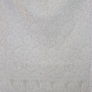 May include: White cotton fabric with a delicate floral pattern. The fabric has a subtle sheen and a soft texture.