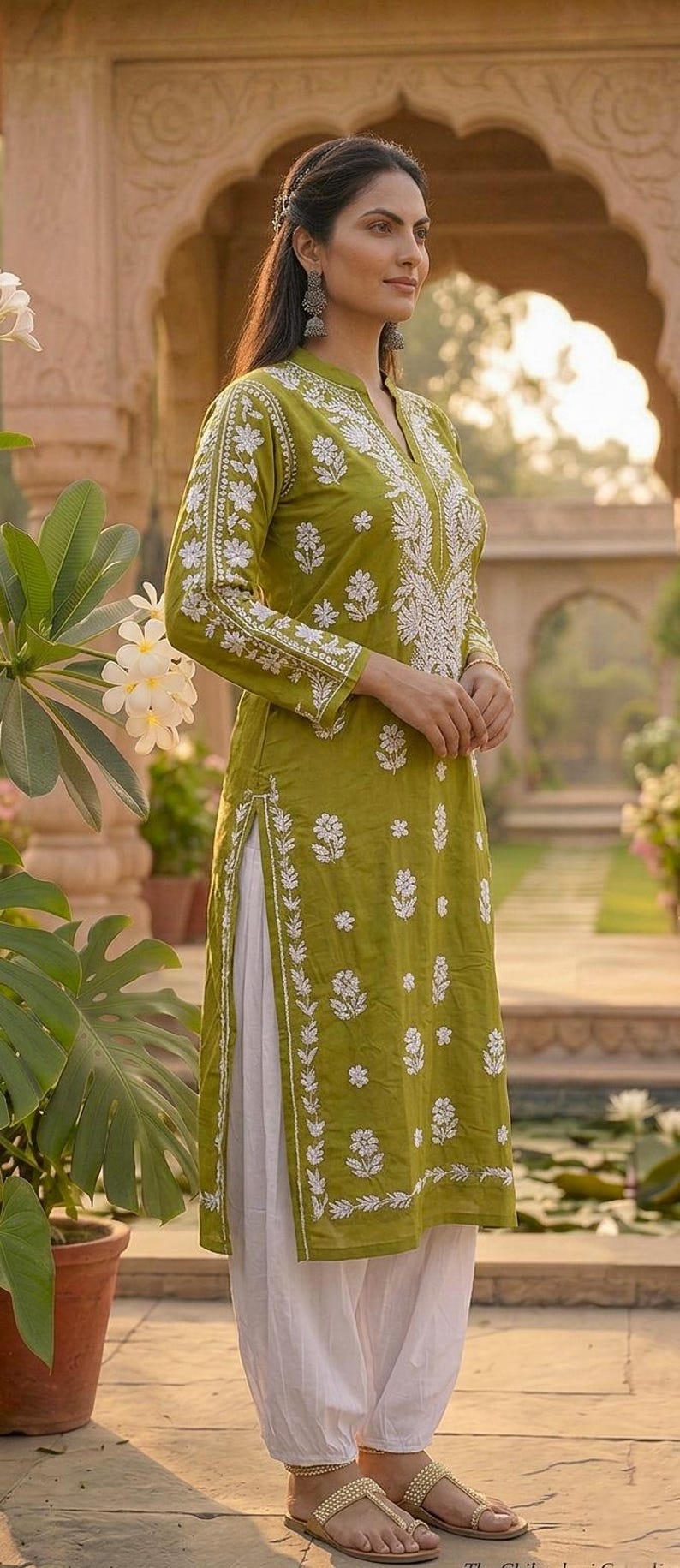 Puede incluir: Kurta bordada en verde oliva con detalles florales blancos. La t&uacute;nica de manga larga se combina con pantalones blancos. El atuendo se usa con sandalias doradas. La ropa es adecuada para ocasiones informales o formales.